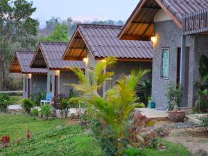 a house with a metal roof and a yard at Tribal Pai in Pai