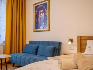 a living room with a blue couch and a bed at Apartmán Jimi Hendrix in Nymburk +4 photos