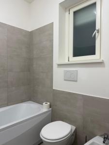 a bathroom with a toilet and a sink and a window at Petrocelli apartment in La Romanina +16 photos