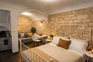 a bedroom with a bed and a stone wall at Tirella Home in Modica