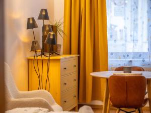 a bedroom with yellow curtains and a table and chair at Apartmán Mick Jagger in Nymburk