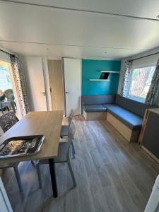 a room with a table and chairs and a couch at Camping les Olyats in Seignosse
