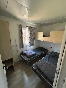 a room with two beds and a bunk bed at Camping les Olyats in Seignosse