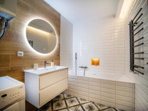 a bathroom with a sink and a tub and a mirror at Apartmán Mick Jagger in Nymburk