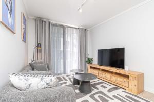 a living room with a couch and a tv at Elegant AirConditioned Neria at Ellipse Waterfall in Midrand
