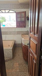 a bathroom with a sink and a tub and a window at Casa Meão in Recife
