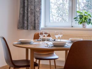 a dining room table with chairs and glasses on it at Apartmán Ve středu dění in Poděbrady +4 photos