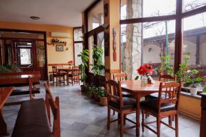 ein Esszimmer mit Tisch, Stühlen und Pflanzen in der Unterkunft Trafi Em in Sofia