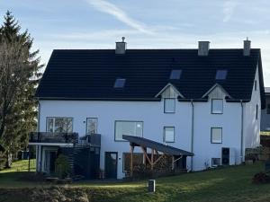 a large white house with a black roof at Auwer Hills - On dr Schür in Auw