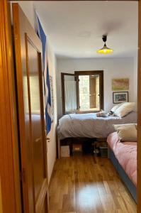 a bedroom with two beds and a window and a door at Chalet Hoz de Jaca in Hoz de Jaca
