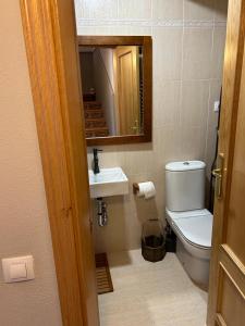 a bathroom with a toilet and a sink and a mirror at Chalet Hoz de Jaca in Hoz de Jaca +11 photos