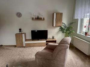 a living room with a couch and a flat screen tv at Ferienwohnung Poschmann in Bad Wilsnack