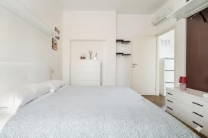 a white bedroom with a large bed and a dresser at Moderno appartamento a 2 passi dal centro in Brescia