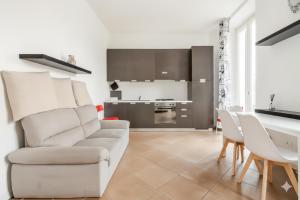 a white living room with a couch and a table at Moderno appartamento a 2 passi dal centro in Brescia