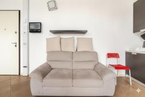 a living room with a couch and a red chair at Moderno appartamento a 2 passi dal centro in Brescia