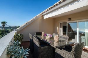 a patio with a table and chairs on a balcony at NEW Duplex Penthouse, Spectacular Ocean View in Manilva