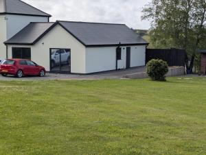 a house with a red car parked in front of it at Allensmore House Gower in Swansea