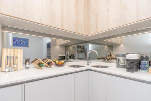 a kitchen with white counters and wooden cabinets at Elegant AirConditioned Neria at Ellipse Waterfall in Midrand