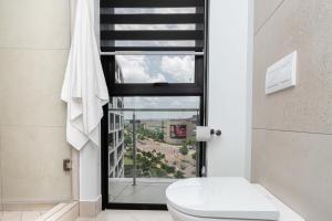 a bathroom with a toilet and a window at Elegant AirConditioned Neria at Ellipse Waterfall in Midrand +15 photos