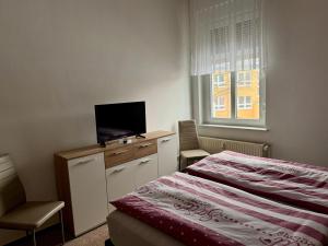 a bedroom with a bed and a desk with a television at Ferienwohnung Poschmann in Bad Wilsnack