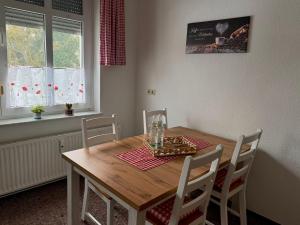 a dining room table with four chairs and a table and a table and chairsktop at Ferienwohnung Poschmann in Bad Wilsnack