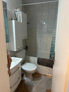 a bathroom with a white toilet and a sink at Apartment Rita in Hannover