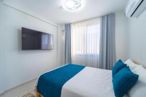 a bedroom with a bed with a tv on the wall at Villa Aden in Fethiye