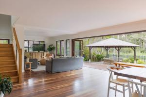 an open living room with wooden floors and large windows at Away Guesthouse- Away on Shirley Lane in Byron Bay