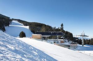 a snow covered slope with a building on the side of a mountain at little alpenapart in Volders