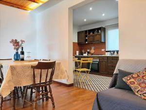 a living room and kitchen with a table and chairs at Tenuta Kiwi dell’Etna in Milo