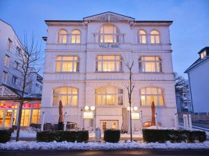 a tall white building with a sign on it at freustil Hotel in Binz