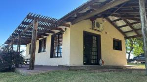 a house with an open door and a wooden roof at Las Dalias in Tacuarembó