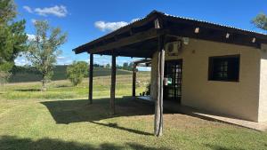 a small building with a roof on the grass at Las Dalias in Tacuarembó +3 photos
