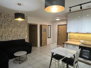 a living room with a black couch and a table at Czarno biały in Racibórz +4 photos