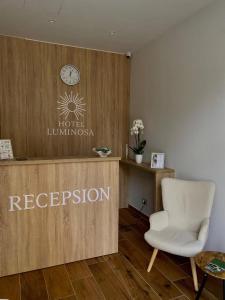 a waiting room with a white chair and a sign at Hotel LUMINOSA in Shkodër