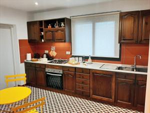 a kitchen with wooden cabinets and a sink at Tenuta Kiwi dell’Etna in Milo +24 photos