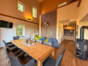 a dining room with a wooden table and a couch at Auwer Hills - On dr Schür in Auw