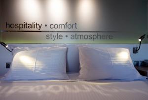 a bed with two pillows and a sign above it at Kanale's Rooms & Suites in Naousa