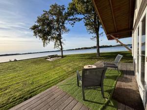a porch with a table and chairs and a view of the water at Vakantiehuis - De Smidse in Haren