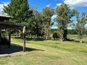 a picnic shelter in a field with trees at Las Dalias in Tacuarembó