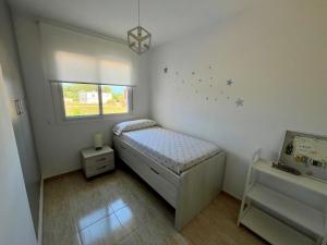 a small bedroom with a bed and a window at Casa Queralt in Les Cases d'Alcanar