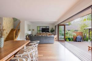 a living room with a couch and a table and chairs at Away Guesthouse- Away on Shirley Lane in Byron Bay