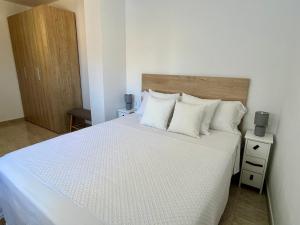 a bedroom with a bed with white sheets and pillows at Casa Queralt in Les Cases d'Alcanar