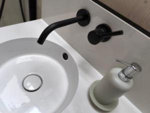 a white toilet with a faucet and a sink at Tiny House 1 im schönen Allgäu mit großem Garten, Naturnah in Bad Wurzach