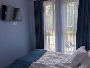 a bedroom with a bed and a large window at Apartamenty Biwakowa 4B in Turawa