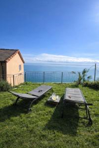 a picnic table and a table and a bench on the grass at Marilú vista mare con giardino in Genoa