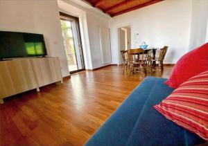 a living room with a couch and a flat screen tv at Tenuta Kiwi dell’Etna in Milo