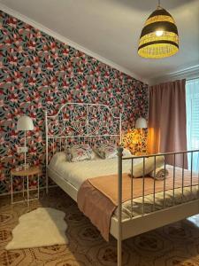 a bedroom with a bed and a wall covered in flowers at Las Casitas de Cullera Sol y Mar in Cullera