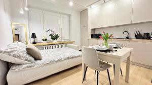 ein Schlafzimmer mit Bett und Tisch und eine Küche in der Unterkunft Studio 39 in Płock
