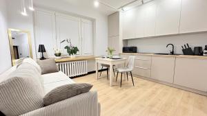 ein Wohnzimmer mit Sofa und Tisch und eine Küche in der Unterkunft Studio 39 in Płock + 5 Fotos
